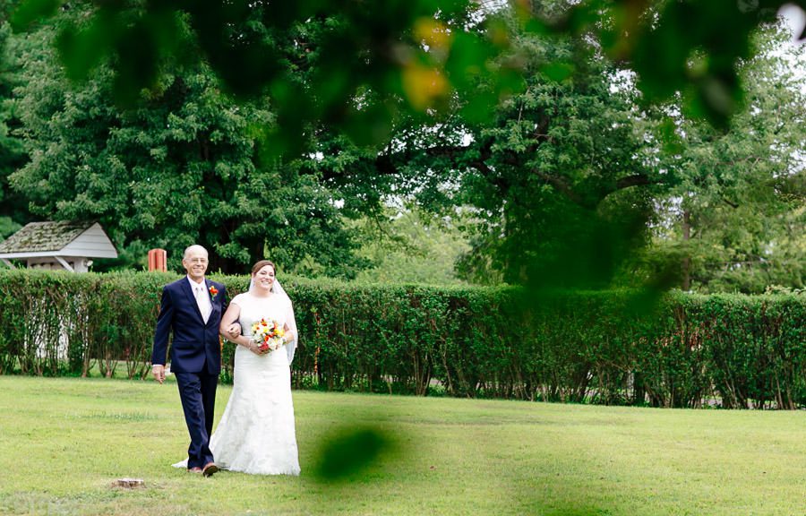 Bride and Father walking to outdoor wedding ceremony