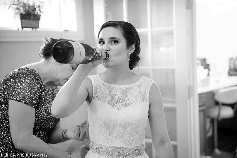 bride taking a drink from champaign bottle